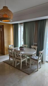 a dining room with a white table and chairs at Duplex Rooftop d'exception terrasse panoramique de 100 m2 in Casablanca
