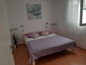a bedroom with a large bed with purple pillows at Apartment Nono Ivo in Vis