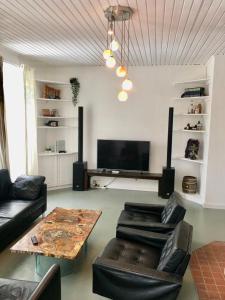 a living room with couches and a table and a tv at Secret Garden Villa in Pörtschach am Wörthersee +28 photos