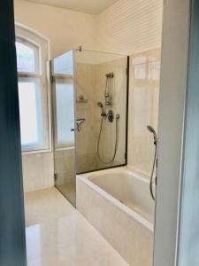 a bathroom with a shower and a bath tub at Secret Garden Villa in Pörtschach am Wörthersee