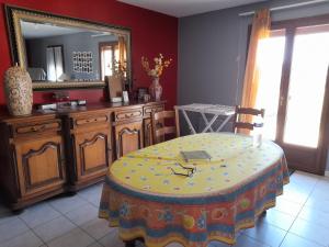 a dining room with a table and a mirror at La belle maisonette in Montmorillon