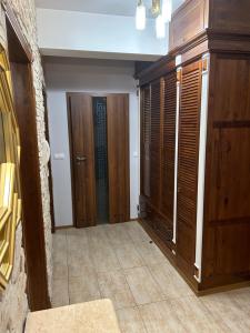 Habitación con armarios de madera y pasillo con puertas. en Apartamenty Modrzewiowa, en Suwałki