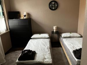 two beds in a room with a clock on the wall at "Ferienwohnung am Schloss" - Ferienwohnung mit Blick auf das Barbyer Schloss, 5 Gehminuten bis zur Elbe in Barby +35 photos