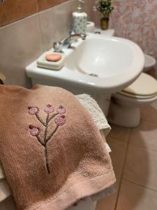 La salle de bains est pourvue d'un lavabo et d'une serviette avec une fleur. dans l'établissement Departamento Tierras del Malbec, à San Rafael