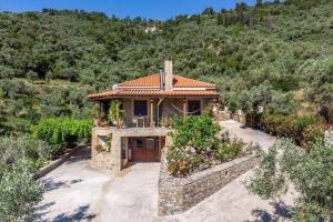 een groot huis met een stenen gebouw met bij Villa Rose Garden in Panormos Skopelos