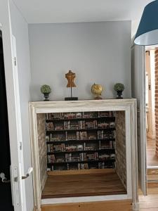 una estantería llena de libros en la sala de estar en Le macareux, maison de pêcheur., en Saint-Valery-sur-Somme