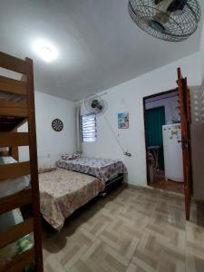 a room with a bed and a refrigerator in it at SUITE CENTRAL BECO DAS FLORES in Jericoacoara