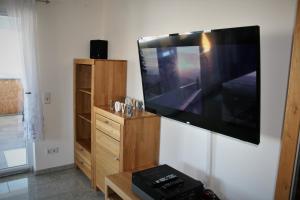 een woonkamer met een grote flatscreen-tv aan de muur bij Ferienwohnung Hochwald 1 in Losheim