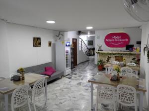 a room with two tables and chairs and a couch at Hotel Amazon in Florencia