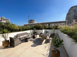 a rooftop patio with tables and chairs and plants at Duplex Rooftop d'exception terrasse panoramique de 100 m2 in Casablanca
