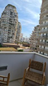a balcony with two chairs and two tall buildings at Duplex Rooftop d'exception terrasse panoramique de 100 m2 in Casablanca