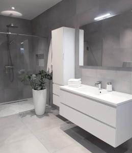 une salle de bain blanche avec un lavabo et une douche dans l'établissement ByMe Torino 85, à Turin