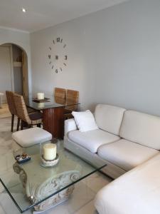 a living room with a couch and a clock on the wall at APARTAMENTO PUERTO BANUS/PLAYA in Marbella