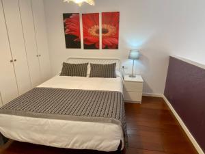 バレンシアにあるPetit Palomar - PalomarGroupのベッドルーム1室(ベッド1台付)が備わります。壁には赤い花の絵が描かれています。