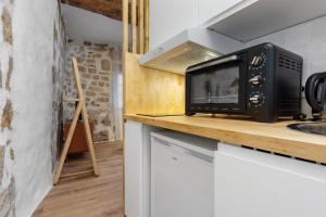 a microwave sitting on a counter in a kitchen at La loge de Sarah in Montpellier