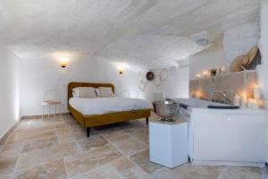 a bedroom with a bed and a kitchen with a sink at La loge de Sarah in Montpellier