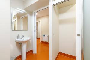 La salle de bains est pourvue d'un lavabo et d'un miroir. dans l'établissement Turoqua Hostel, à Pontevedra
