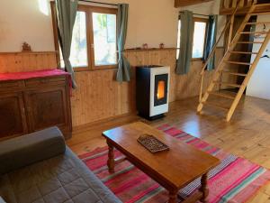 a living room with a wood burning stove in it at Chalets & Camping Villa Mayari in Escosse