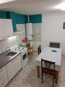 a kitchen with a stove and a table with chairs at Vientos Del Sur in Río Gallegos