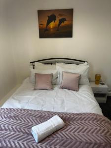 ein weißes Bett mit zwei Kissen und einem Gemälde an der Wand in der Unterkunft Stylish Town House - Modern double room - 5 in Parkside