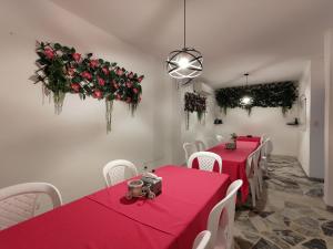 a dining room with red tables and white chairs at Hotel Amazon in Florencia