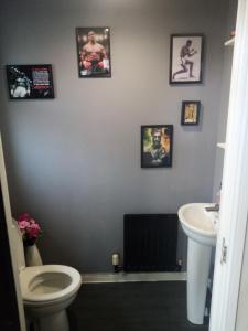 a bathroom with a toilet and a sink and pictures on the wall at Private room in BS14 in Bristol +3 photos