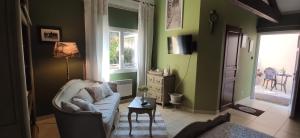 a living room with green walls and a couch at LE BOUILLARY in Cussac