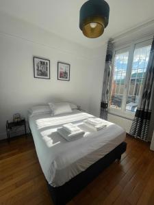 een slaapkamer met een bed met handdoeken erop bij appartement a 15 minute de centre de paris in Saint-Ouen