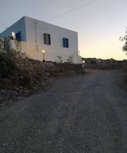 a building on a hill next to a dirt road at Cycladic Villa in Amorgos Island (Maison Shiro) in Arkesíni