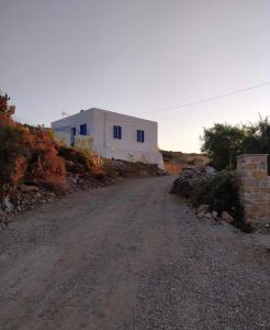 a dirt road in front of a white building at Cycladic Villa in Amorgos Island (Maison Shiro) in Arkesíni