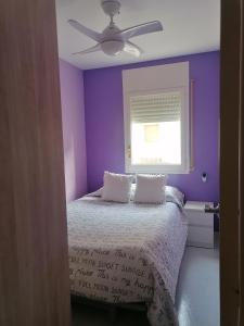 a purple bedroom with a bed with two pillows at Ideal apartamento a 100m playa - Calafell in Calafell