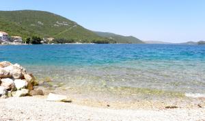 a beach with a large body of water at Apartments Bubica in Luka