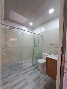 a bathroom with a glass shower and a toilet at VILLA CARO in Palestina
