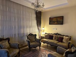 - un salon avec un canapé, des chaises et un lustre dans l'établissement a historical apartment, à Istanbul