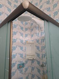 eine Glasduschtür mit einem Licht an der Wand in der Unterkunft Recanto dos Amigos in Praia Grande + 12 Fotos