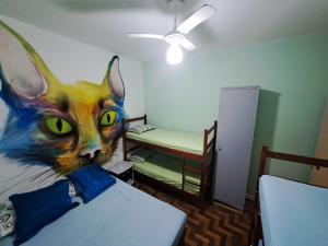 ein Zimmer mit einem Bild einer Katze an der Wand in der Unterkunft Recanto dos Amigos in Praia Grande