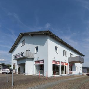 a white building with a car parked in front of it at Ferienwohnung Hochwald 1 in Losheim
