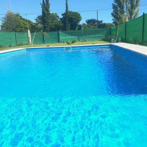 a large blue swimming pool with blue water at AMOR & MIEL in General Alvear