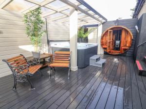 a deck with a table and benches and a tub at The Red Well Country Inn in Carnforth