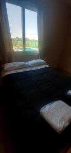 2 camas en una habitación con ventana en AMOR & MIEL en General Alvear