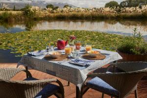 een tafel met eten en drinken naast een meer bij Matuka Lodge in Twizel