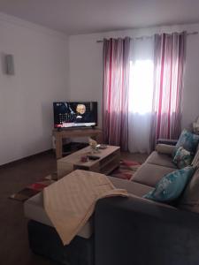 ein Wohnzimmer mit Sofa und Fernseher in der Unterkunft Casa dos avós in Alvor