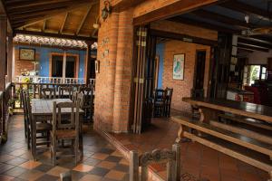 a restaurant with wooden tables and chairs and a brick wall at Rincon Oibano in Oiba