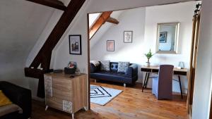 a living room with a blue couch and a table at Appart plein centre, vue cathédrale, fibre in Lisieux