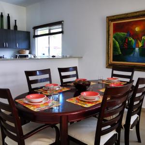 a dining room table with red plates and chairs at Lulu Village - Beach - Pool - Pet Friendly in Coclé