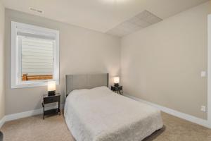 a white bedroom with a bed and two night stands at Luxurious Woodinville WA Guest Suite for Rent in Woodinville