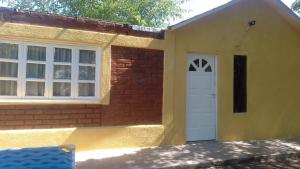 una casa con una puerta blanca y una pared de ladrillo en CASA VISTALBA en Luján de Cuyo