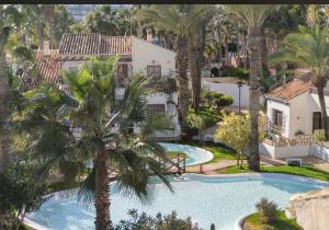 una vista aérea de una piscina con palmeras en Casa con Encanto en Roquetas de Mar, en Roquetas de Mar