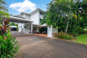 a white house with a driveway in front of it at Seascape Holidays - Coral Apartments in Port Douglas