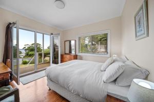 a bedroom with a large bed and a large window at Bowen View in Hyams Beach